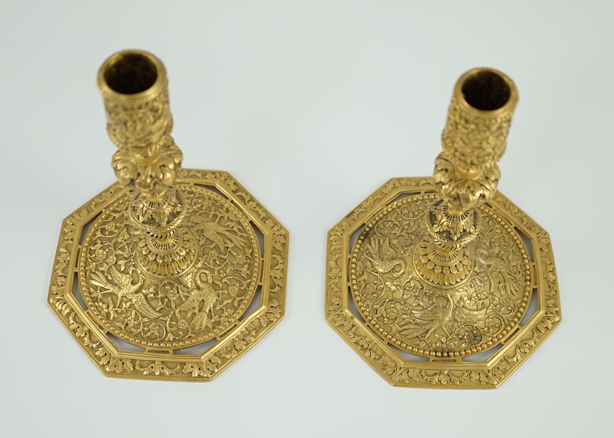 An ornate pair of Victorian silver gilt dwarf candlesticks, by John Wilmin Figg